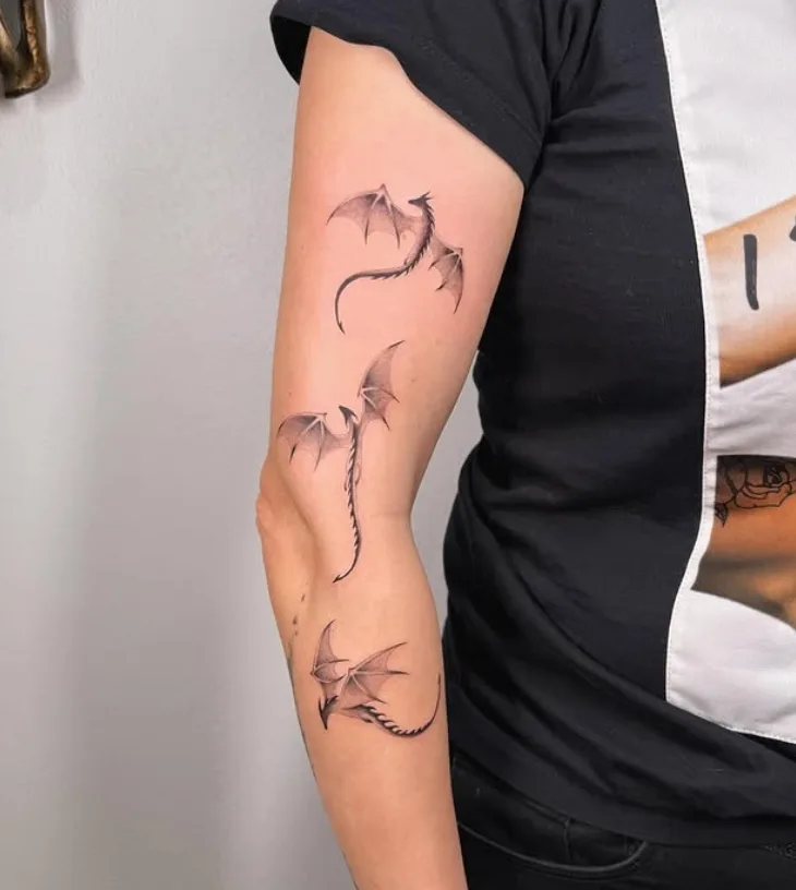 Drachenmotive als feines Tattoo am Arm