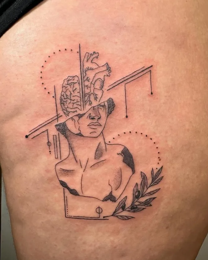Schleifen- und Kreuzmotiv als Tattoo am Unterarm